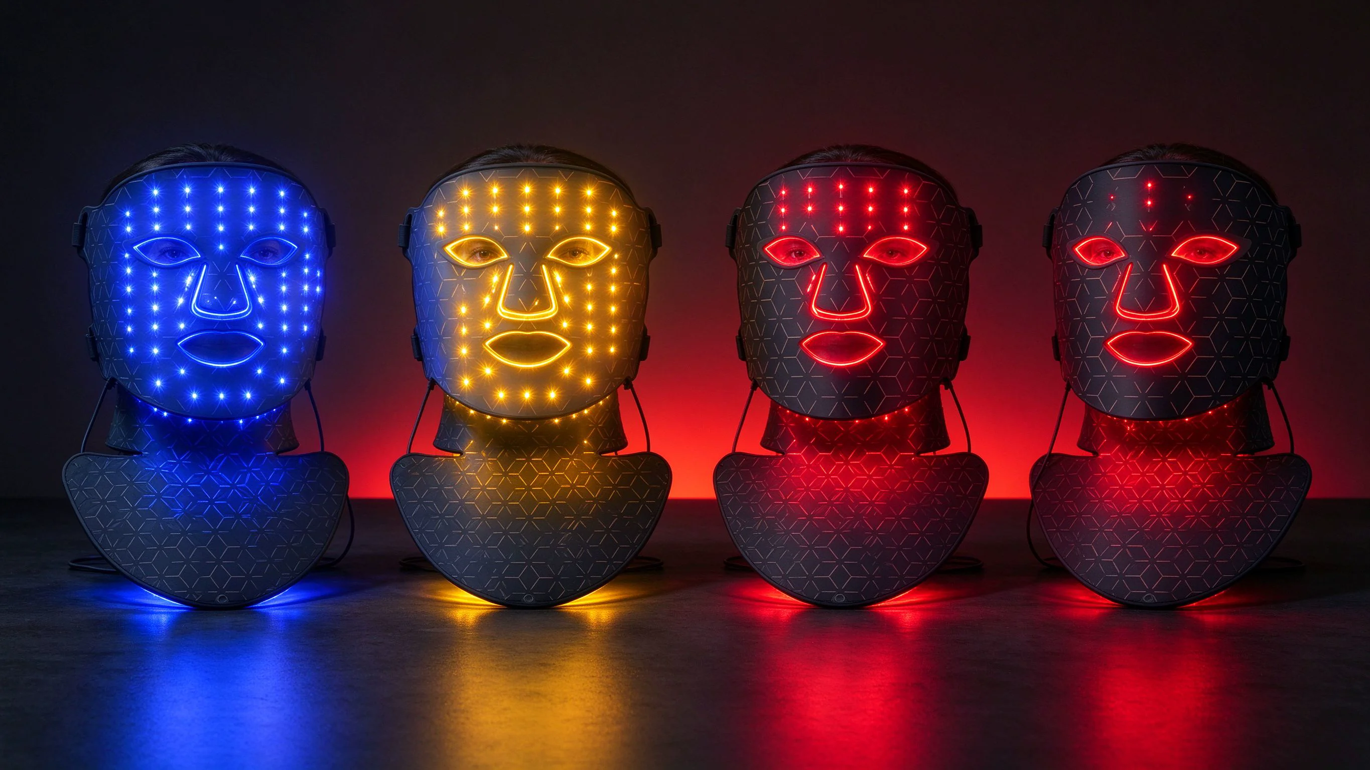 Four LED masks glowing blue, yellow, red and infrared