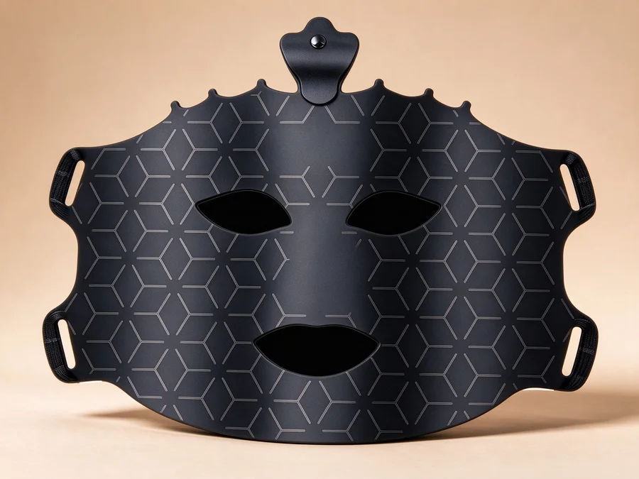 Qcured RGB liquid silicone facemask in black, front view with control module on top and openings for eyes, nose and mouth